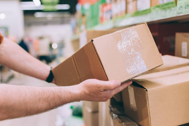 a man hand holding a box in a fulfillment warehouse